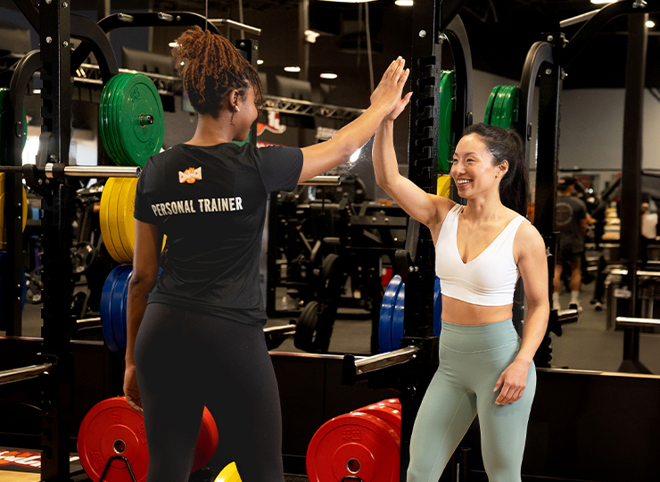gym-goer working out with personal trainer