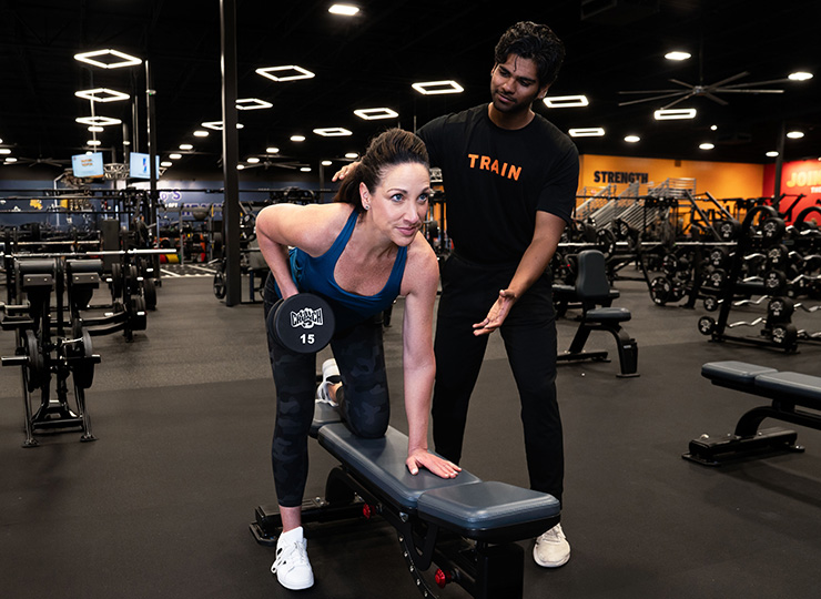 gym goer working out with trainer