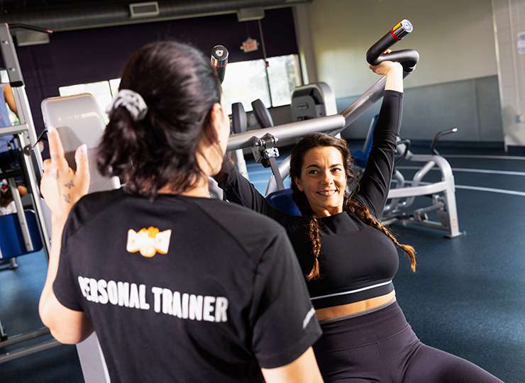 gym-goer working out with personal trainer