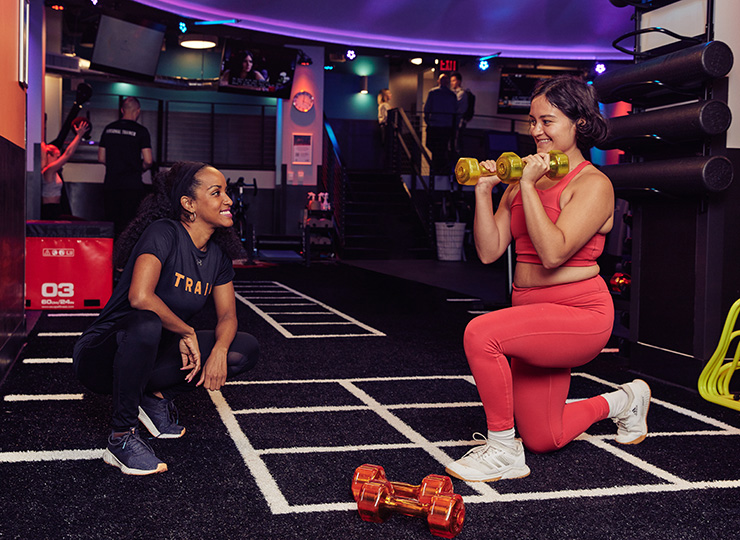 gym-goer working out with personal trainer