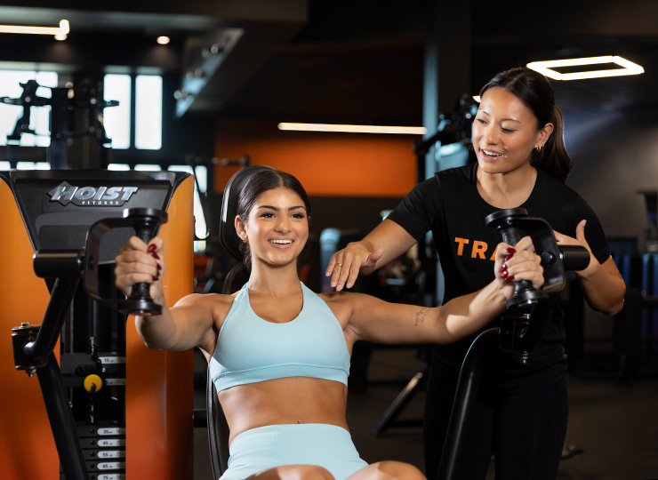 gym-goer getting workout help with personal trainer