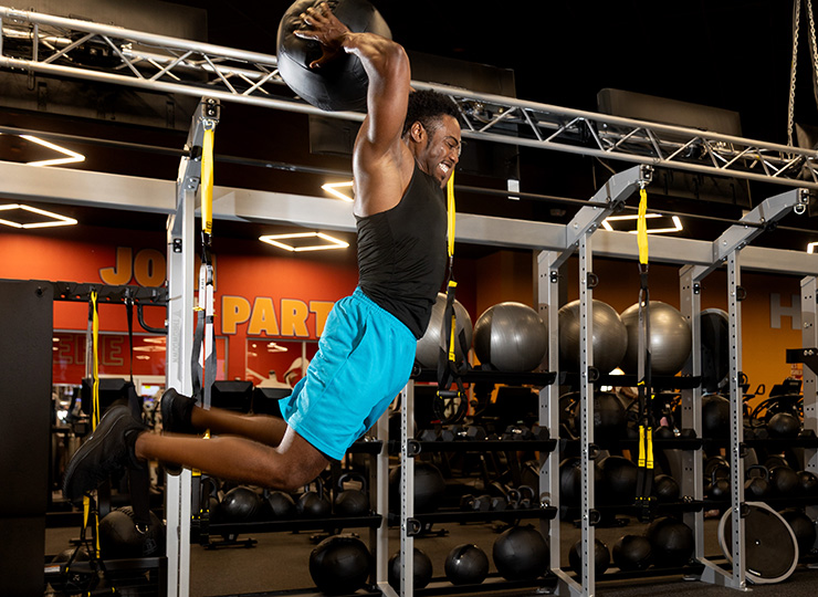 gym-goer jumping with weighted ball